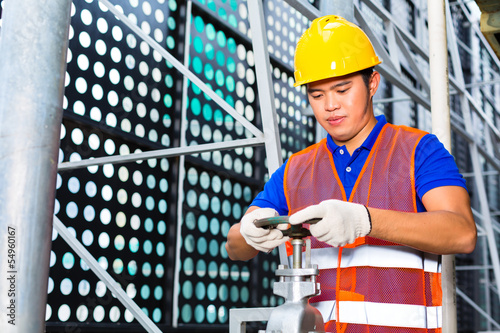 Chinese Technician or engineer working on valve photo