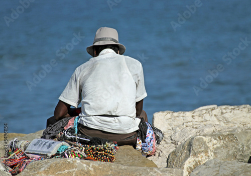 peddler of necklaces and accessories rests on the Pier by the se photo