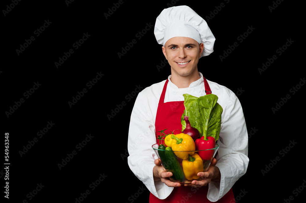 Handsome chef holding vegetables bowl Handsome chef holding vegetables bowl