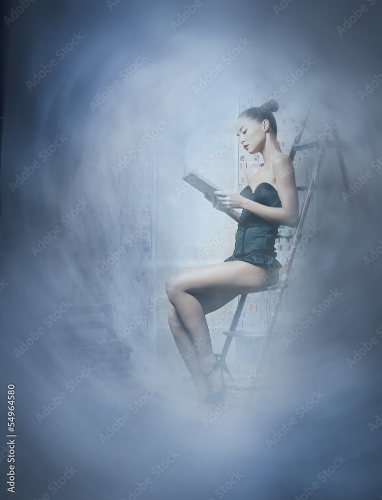 Fashion shoot of a young brunette woman reading a book