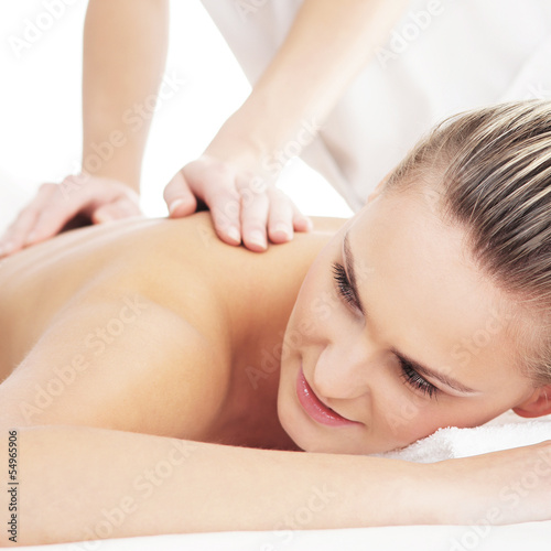 A young blond woman on a back massage procedure