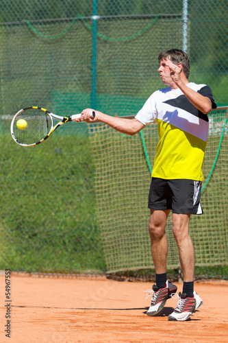 tennis player hits forehand ball on court © A2LE
