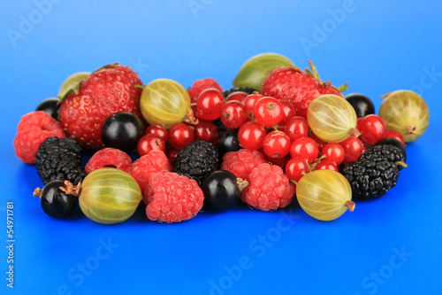 Ripe berries on blue background