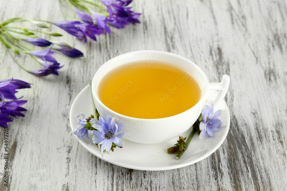 Cup of tea with chicory, on wooden background Cup of tea with chicory, on wooden background