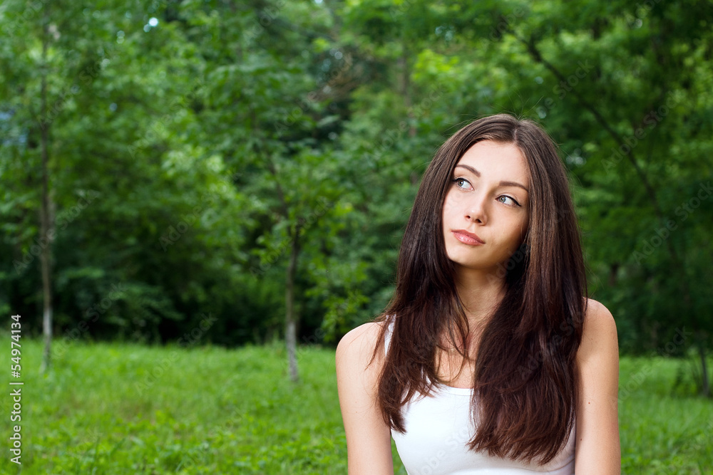 Thoughtful young woman outside in park Thoughtful young woman outside in park