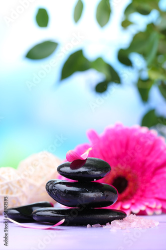 Spa stones and beautiful gerbera on wooden table