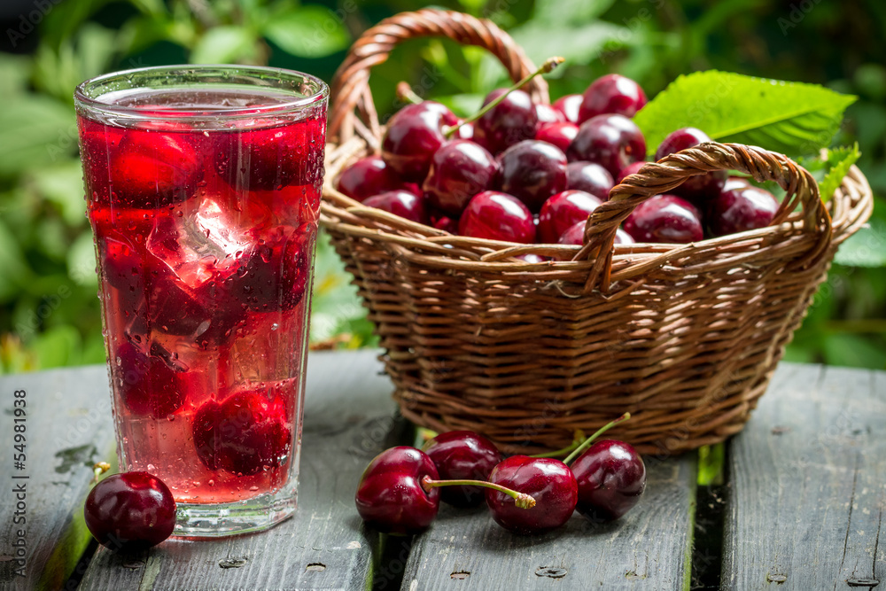 Freshly harvested sweet cherries and juice from them with ice Freshly harvested sweet cherries and juice from them with ice