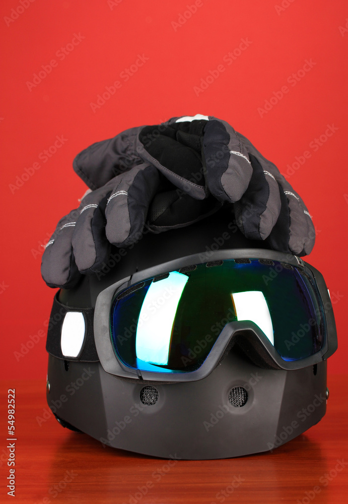 Winter sport glasses, helmet and gloves, on red background Winter sport glasses, helmet and gloves, on red background