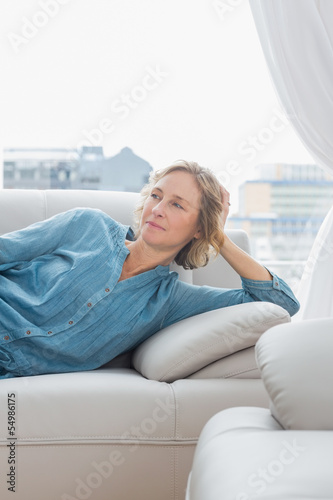 Thoughtful woman relaxing on her couch