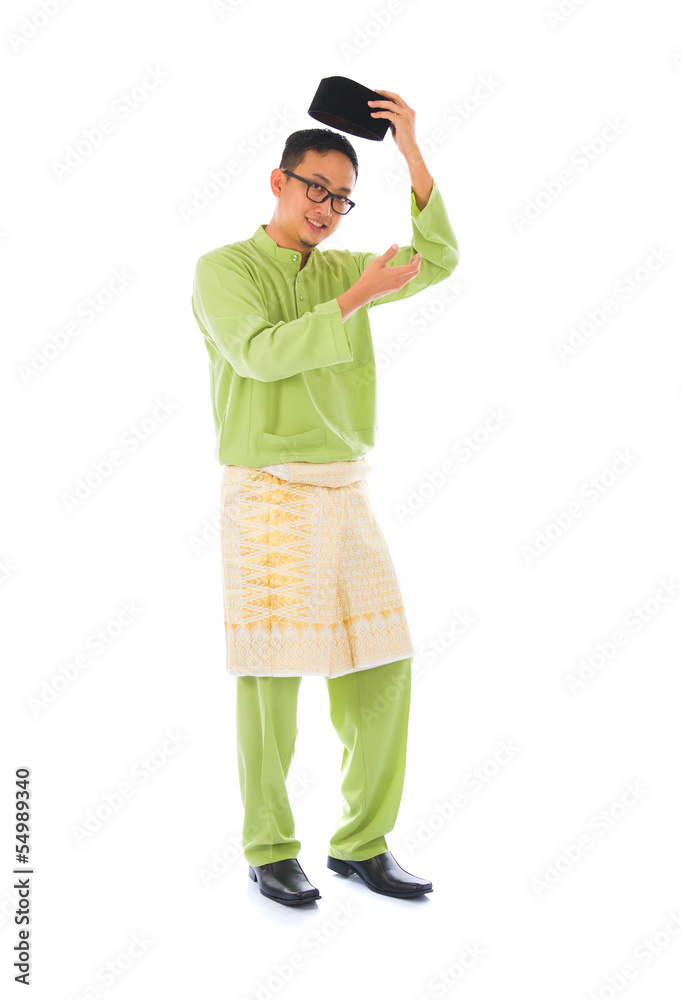 Asian muslim male with traditional Malay costume in smiling acti Asian muslim male with traditional Malay costume in smiling acti
