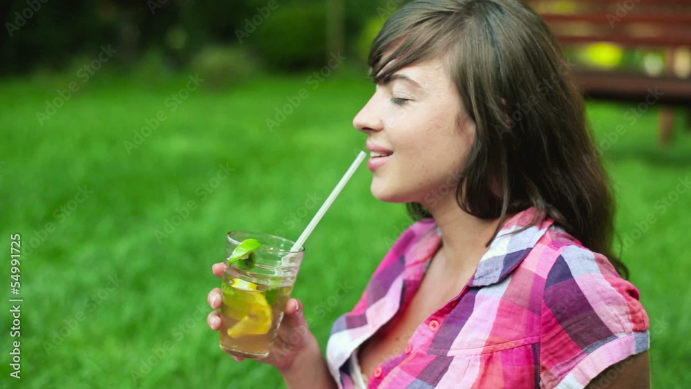 Portrait of happy young woman drinking lemonade in park Portrait of happy young woman drinking lemonade in park