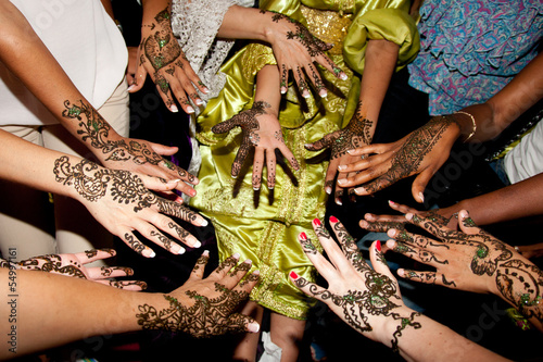 cérémonie de tatouage au henné sur les mains par un groupe de femmes photo