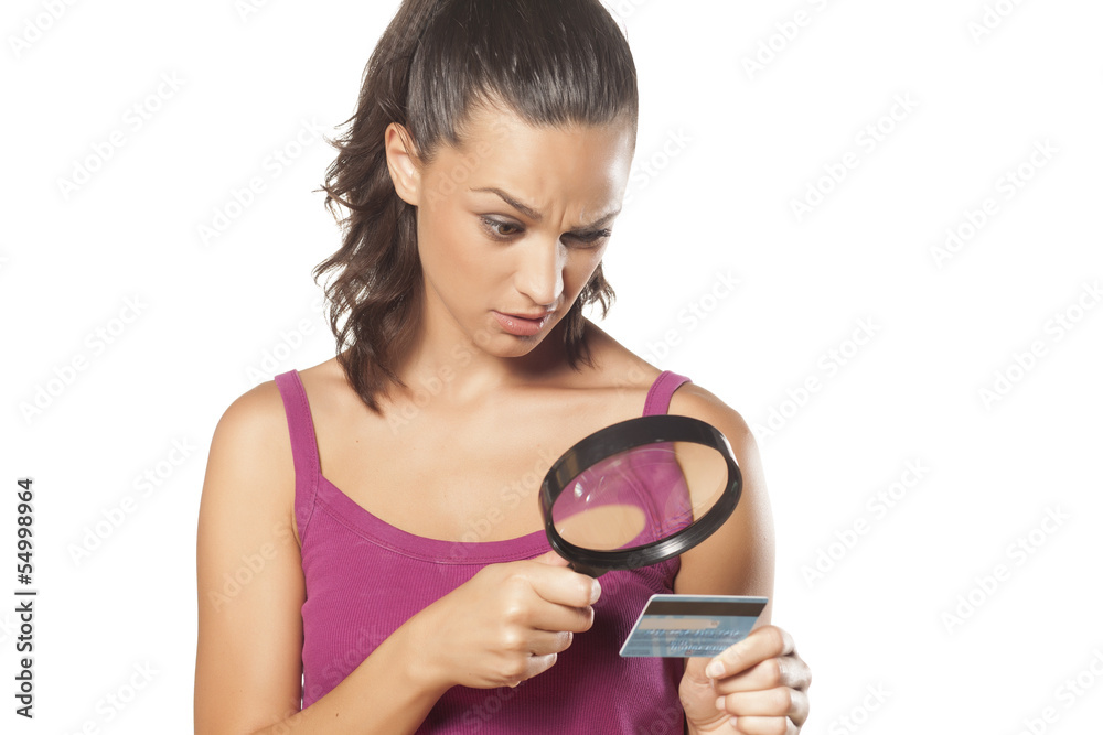 Suspicious girl looking her credit card Suspicious girl looking her credit card