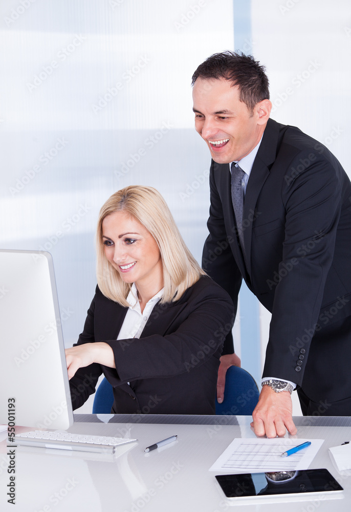 Two Businesspeople Looking At Computer Two Businesspeople Looking At Computer