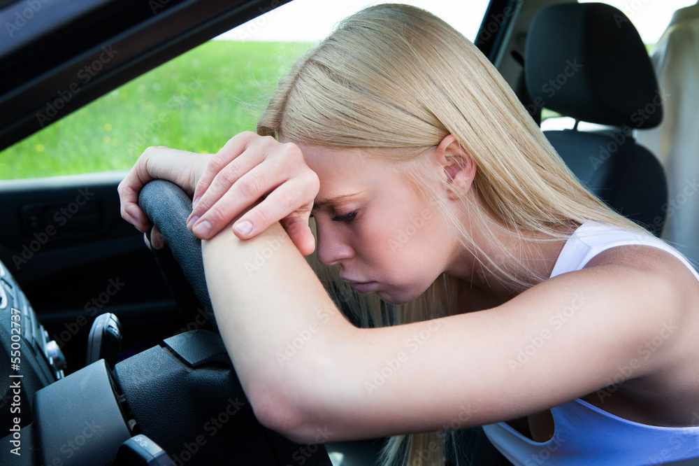 Woman Leaning Head On Steering Wheel