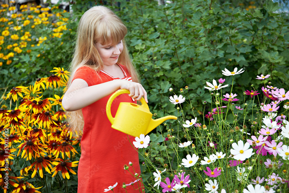 Little girl watering flowers