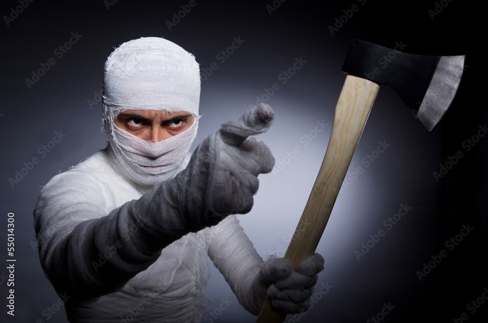 Mummy with axe in halloween concept Mummy with axe in halloween concept