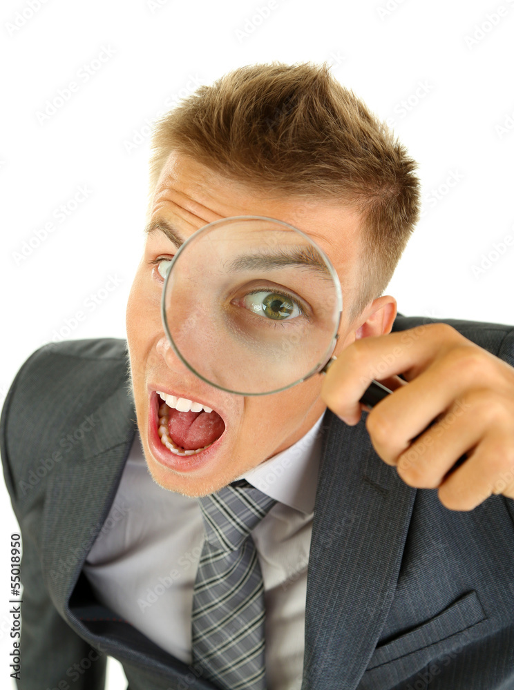 Young businessman looking through magnifying glass isolated Young businessman looking through magnifying glass isolated