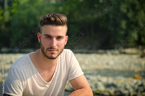 Portrait of handsome young man in white t-shirt outdoors