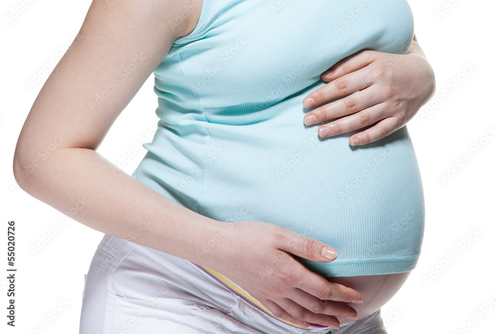 Closeup of a pregnant woman's stomach, isolated on white