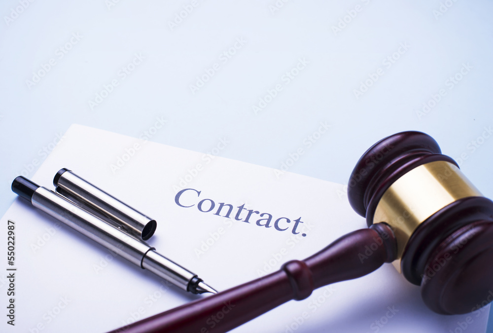 brown gavel on the table and the contract