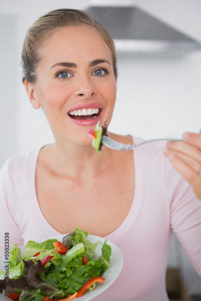 Pretty blonde eating salad