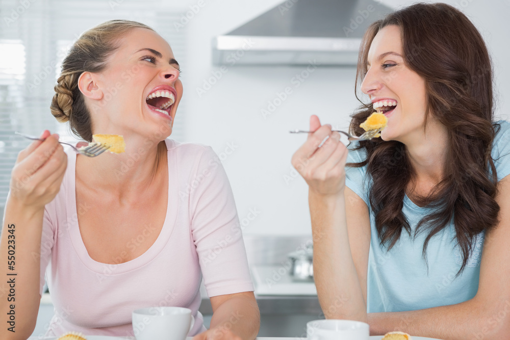 Laughing friends eating cake and having coffee Laughing friends eating cake and having coffee