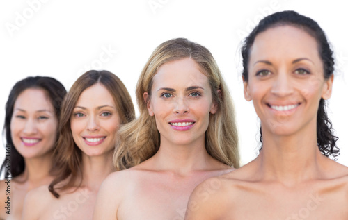 Smiling nude models posing in a line looking at camera