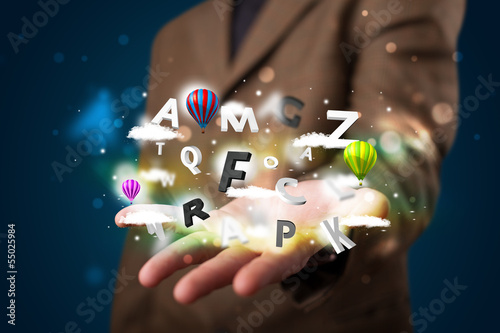 Young businessman presenting magical clouds with letters and bal