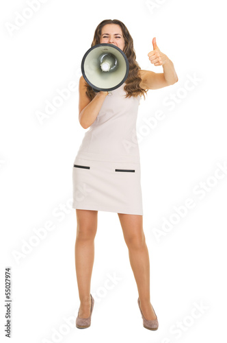Full length portrait of young woman shouting through megaphone a