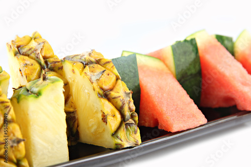 Pineapple and Watermelon slice Arranged in the black dish.