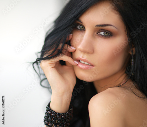 the beautiful girl with long dark hair looks out of the window