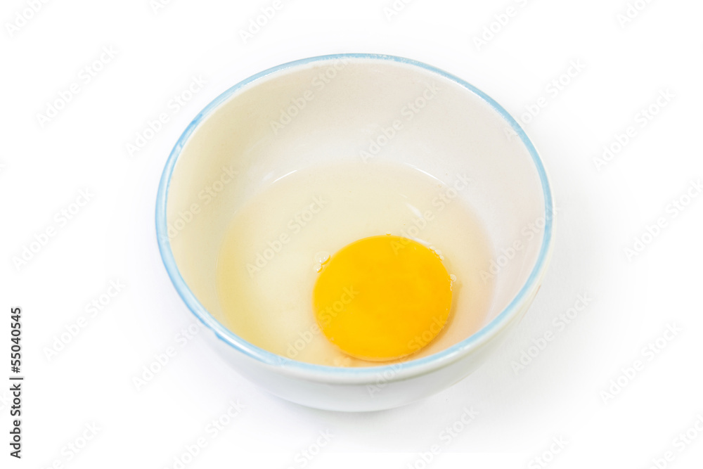 The cracked egg in ceramic bowl with isolated white background The cracked egg in ceramic bowl with isolated white background