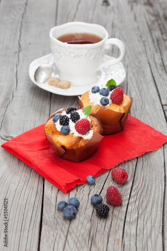 Tasty cupcakes with berries on wooden table