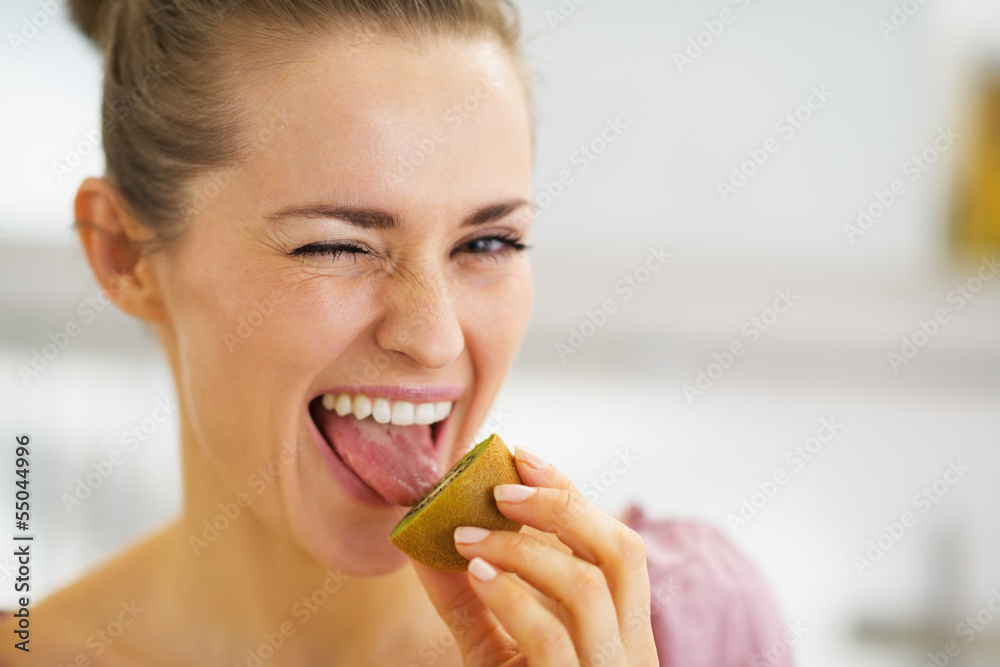 Young woman tasting kiwi Young woman tasting kiwi