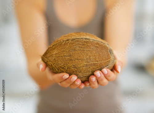 Closeup woman showing coconut