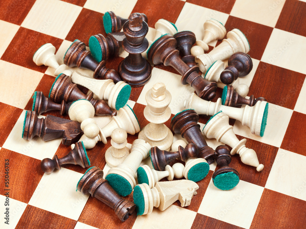 king in middle of spillage of chess pieces king in middle of spillage of chess pieces