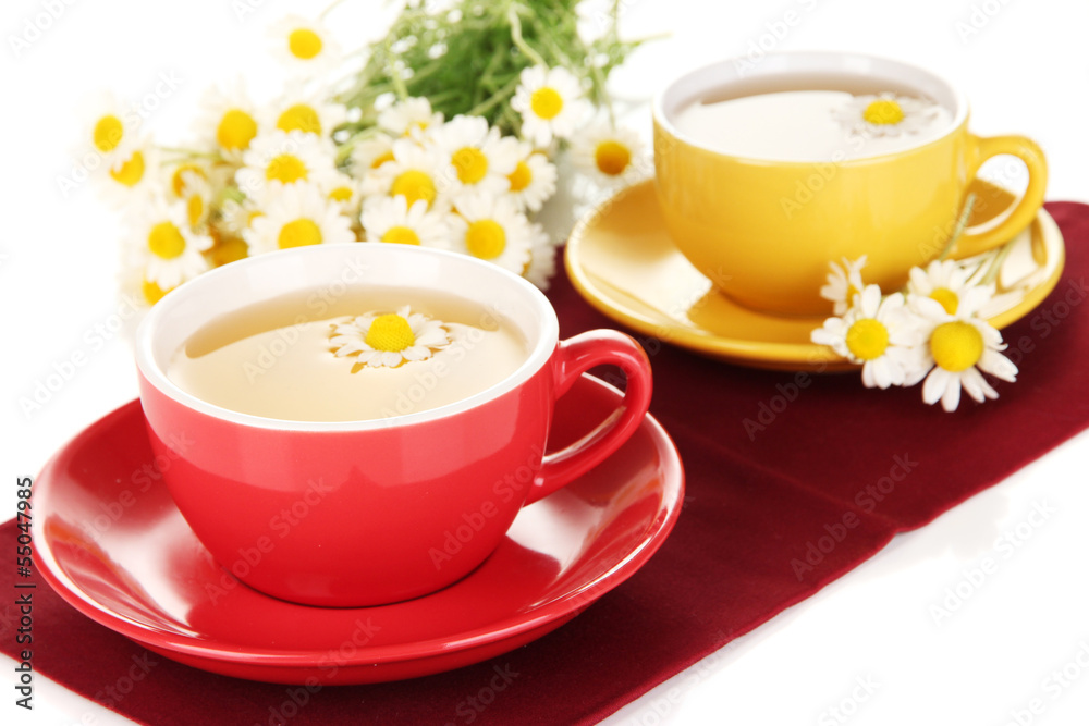 Fototapeta premium Cups of herbal tea with camomiles close up