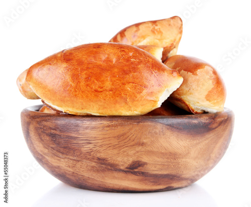 Fresh baked pasties in wooden bowl, isolated on white