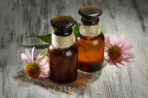 Fototapeta Naklejka Na Ścianę i Meble -  Medicine bottles with purple echinacea flowers on wooden table