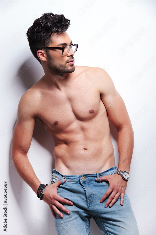 topless young man looks to his side
