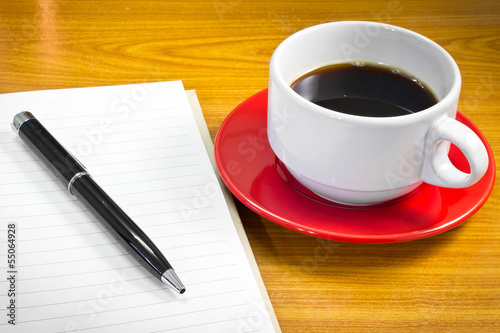 Note book and pen with a cup of coffee