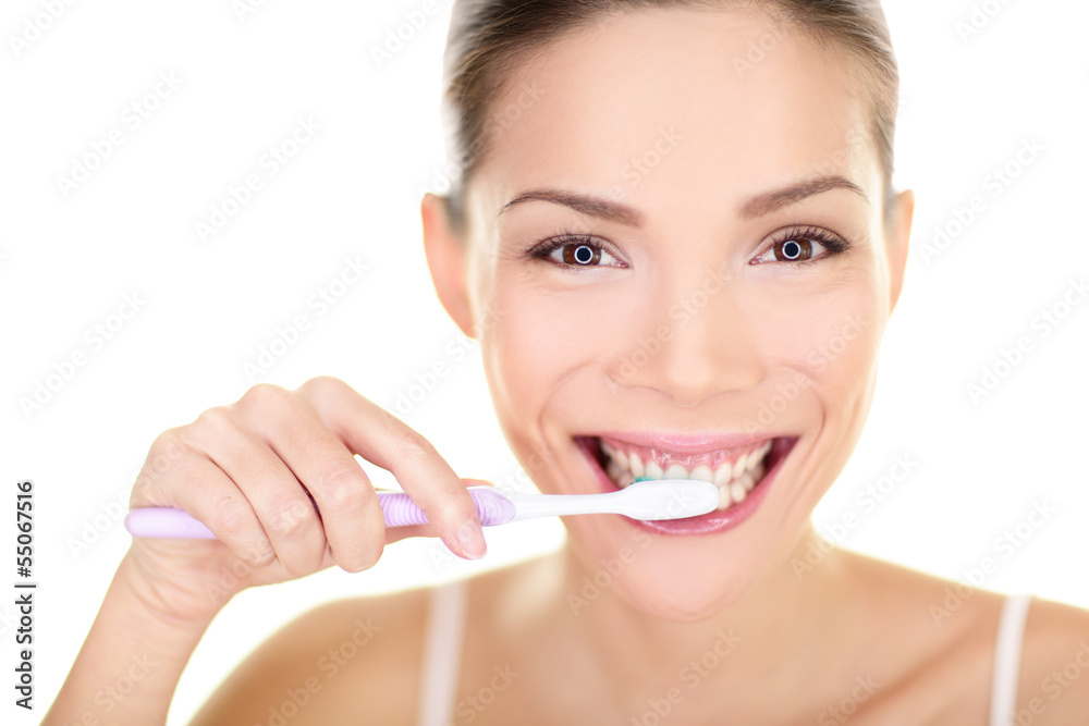 Woman brushing teeth holding toothbrush Woman brushing teeth holding toothbrush