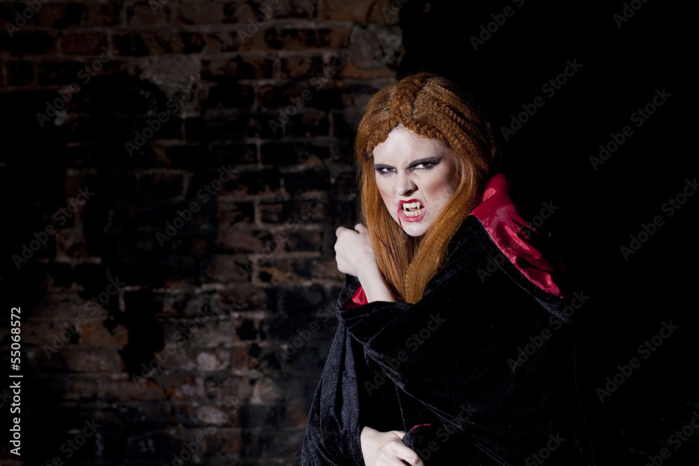 Terrible vampire woman in a red cloak