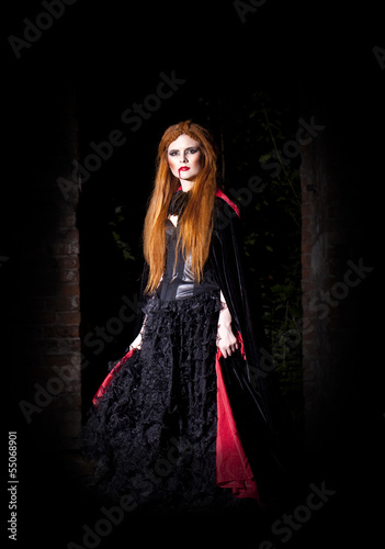 Terrible vampire woman in a red cloak