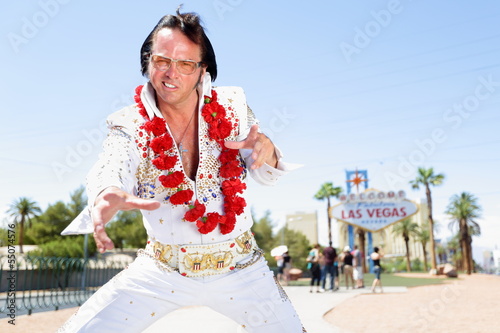 Elvis impersonator dancing by Las Vegas sign photo