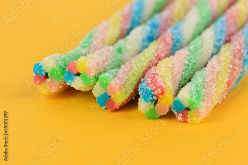 Sweet jelly candies on yellow background