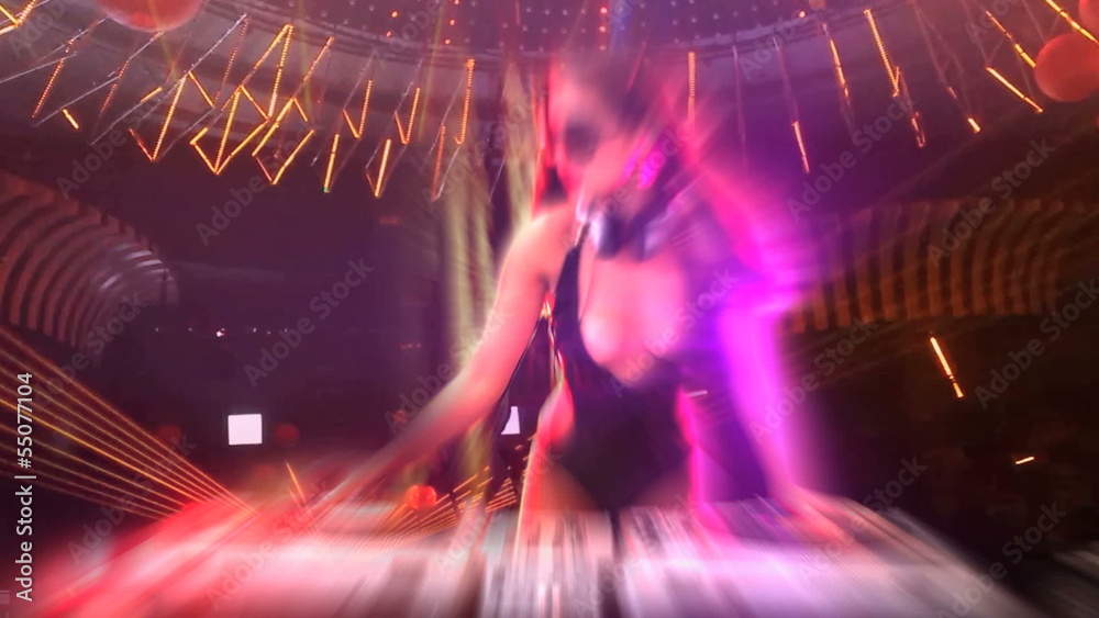DJ at work mixing sound on her decks at a party