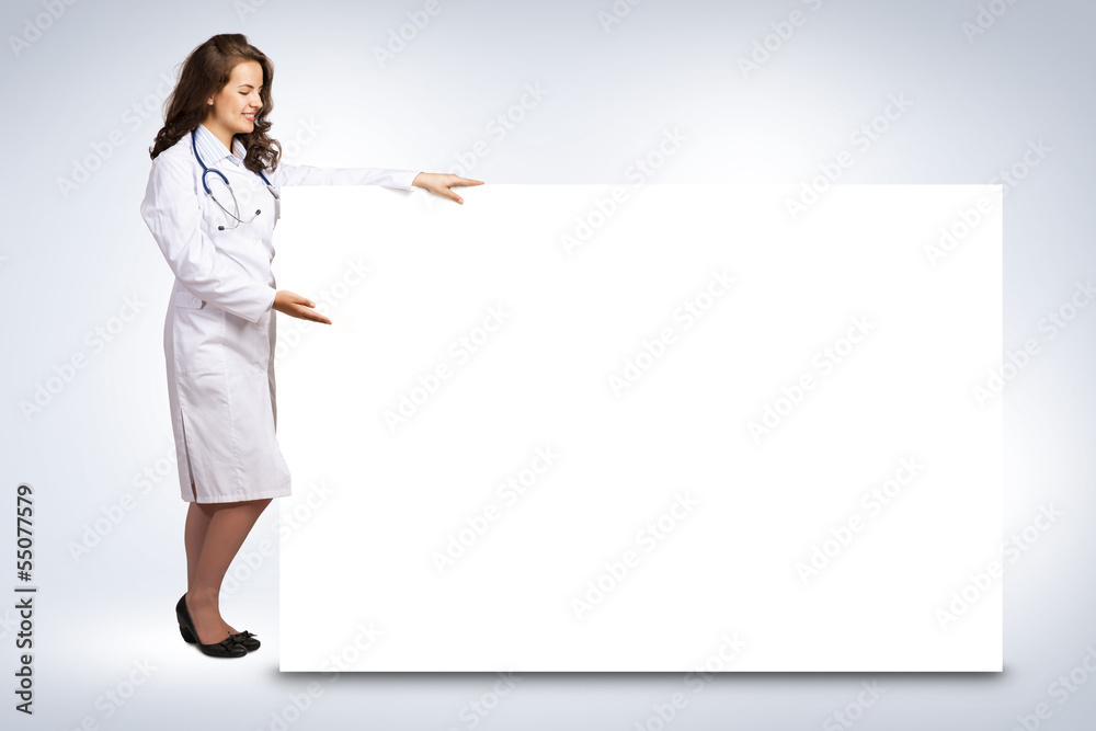 young woman doctor standing near a blank banner young woman doctor standing near a blank banner