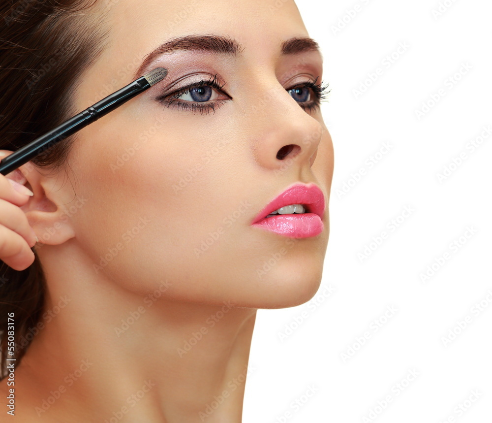 Beautiful woman applying the brush luxury eyeshadows. Closeup is